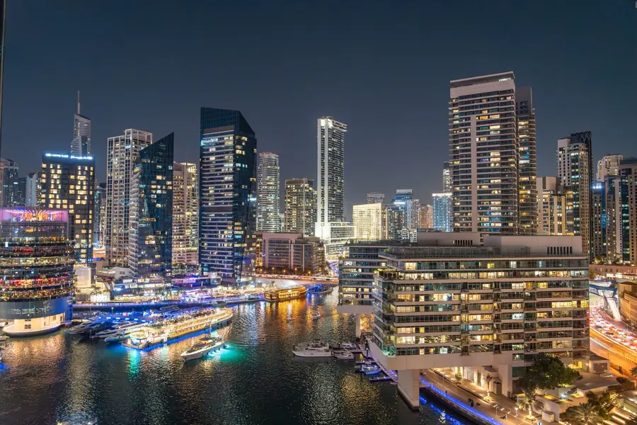 Dubai Marina at night, yachts moored below lit towers