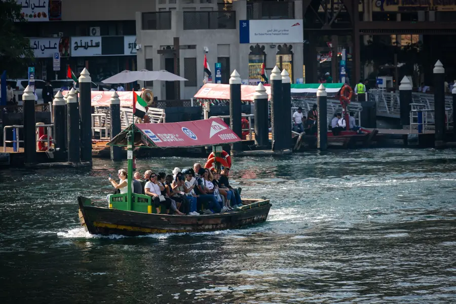 A loaded abra crossing Dubai Creek in front of the old waterfront