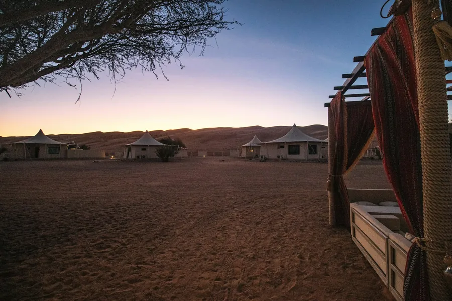 A desert camp with Bedouin-style tents at dusk