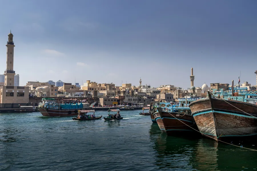Wooden dhows moored along Dubai Creek beside the old waterfront