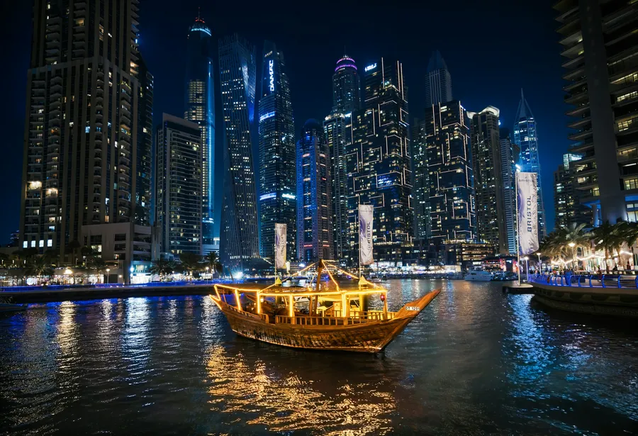 An illuminated dhow cruising Dubai Marina at night